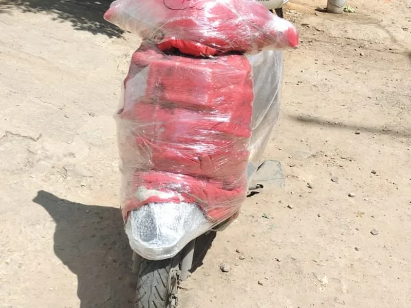 Two-wheeler scooter securely packed with red protective padding and stretch film for relocation