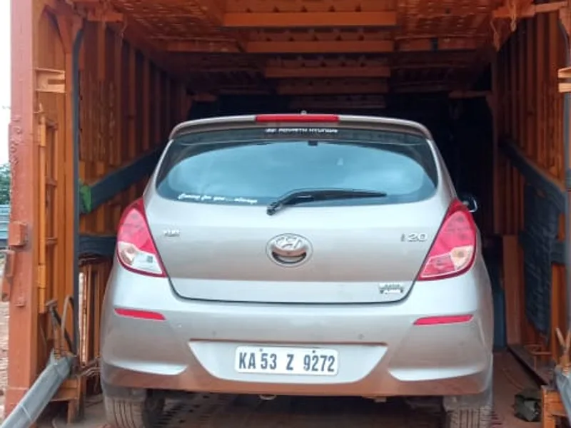 Hatchback automobiles loaded onto hydraulic decks inside specialized vehicle carrier