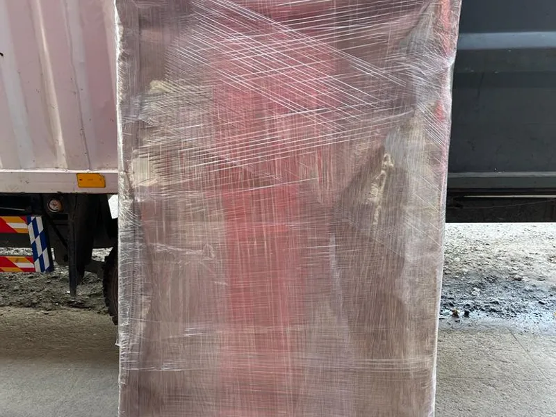 Tall household storage unit wrapped in corrugated board and industrial stretch wrap