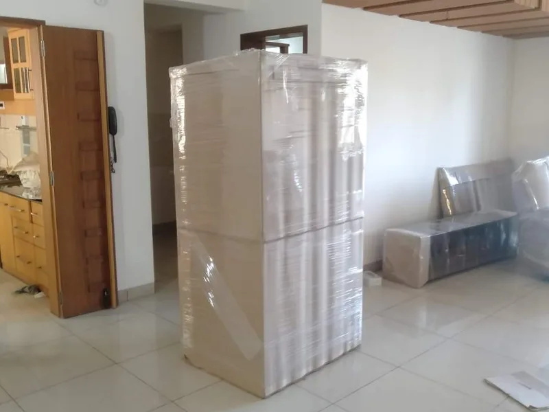 Tall storage cabinet wrapped in protective corrugated sheets standing in living room