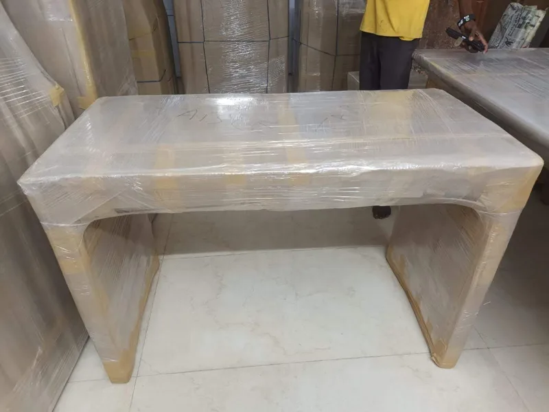 Solid wood office workstation desk wrapped cleanly in transparent stretch wrap