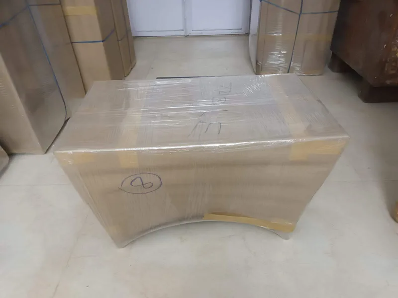 Large wooden reception desk wrapped in protective foam and tape in commercial storage